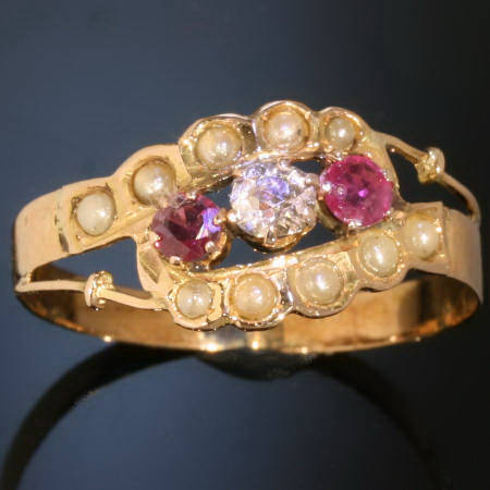 Antique three stone crossover ring with rubies and one old mine cut diamond